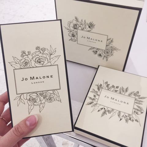 Three Jo Malone gift boxes on display with custom floral illustrations decorating the logo